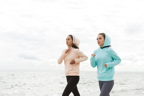 Dos hermosas mujeres jóvenes fitness corriendo al aire libre — Foto de Stock