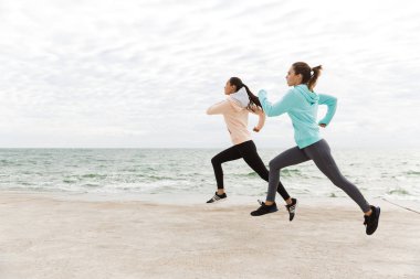 İki güzel genç fitness kadın açık havada koşu