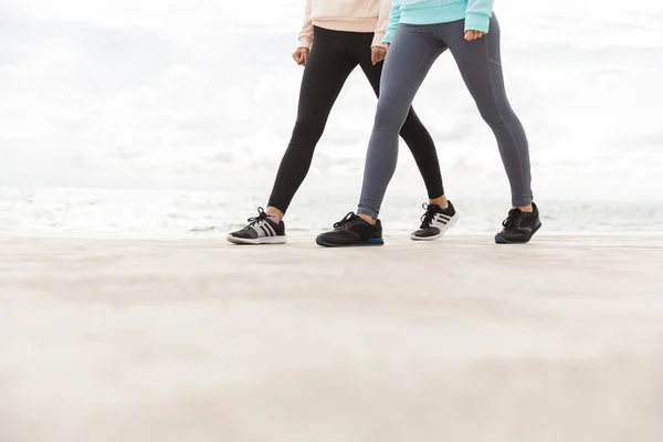 Обрезанный наполовину образ двух молодых фитнес-женщин — стоковое фото