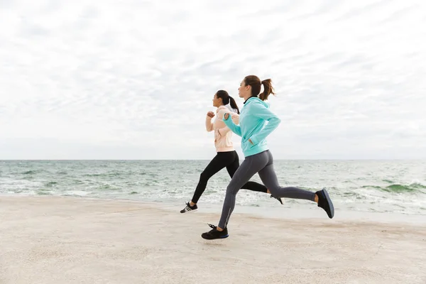 Dos hermosas mujeres jóvenes fitness corriendo al aire libre — Foto de Stock