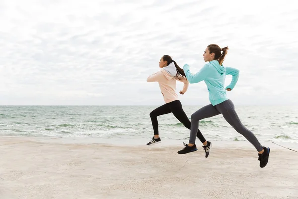 Dos hermosas mujeres jóvenes fitness corriendo al aire libre — Foto de Stock