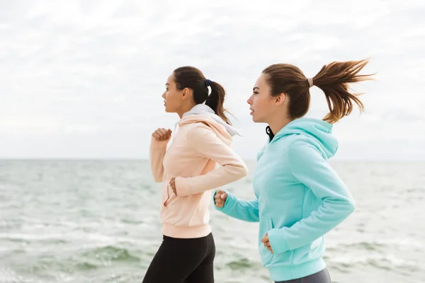 Dos hermosas mujeres jóvenes fitness corriendo al aire libre — Foto de Stock