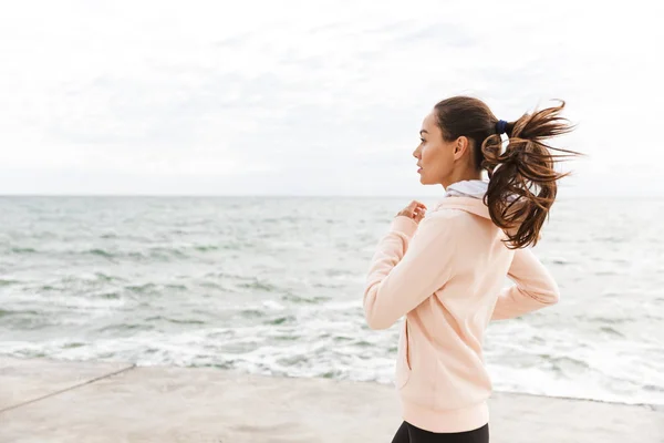 Attraktiv ung asiatisk idrottskvinna utövar vid stranden — Stockfoto