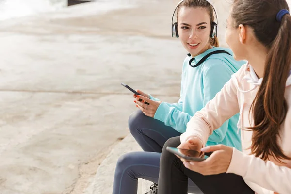 Two pretty smiling fitness women wearing hoodies — Stock Photo, Image
