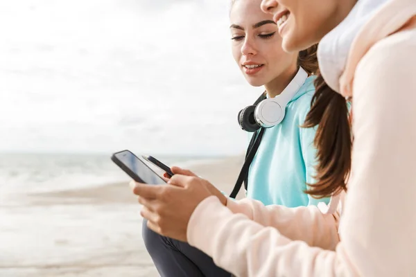 Two pretty smiling fitness women wearing hoodies — Stock Photo, Image