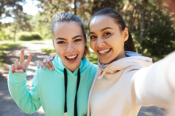 Mulher atraente sorrindo fitness vestindo capuzes trabalhando fora — Fotografia de Stock