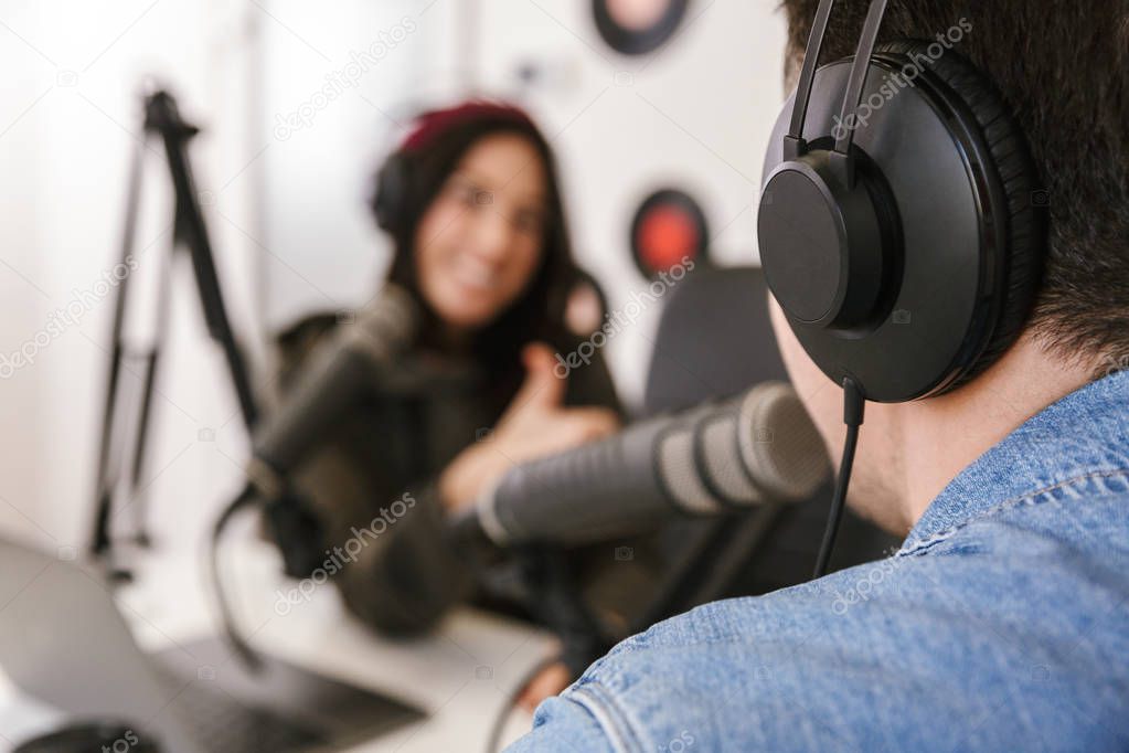 Man and woman in white shirts podcasters interview