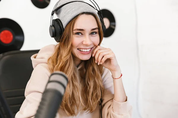Beautiful happy young female radio host broadcasting