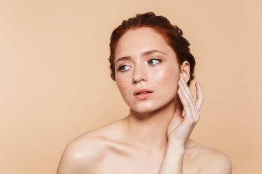 Bej duvar arka plan üzerinde izole poz Amazing genç kızıl saçlı kadın.