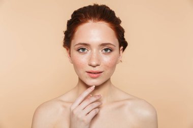 Bej duvar arka plan üzerinde izole poz Amazing genç kızıl saçlı kadın.