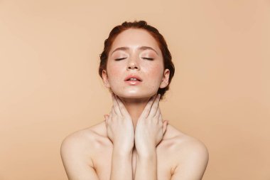 Bej duvar arka plan üzerinde izole poz Amazing genç kızıl saçlı kadın.