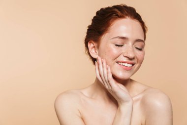 Bej duvar arka plan üzerinde izole poz Amazing genç kızıl saçlı kadın.