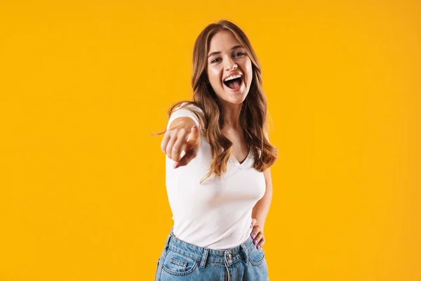 Image gros plan d'une femme caucasienne ravie portant un t-shirt basique souriant et pointant du doigt la caméra — Photo