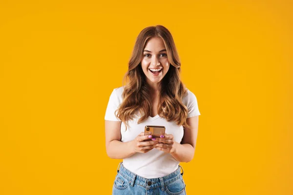 Зображення крупним планом красива біла жінка в базовій футболці посміхається при використанні мобільного телефону — стокове фото