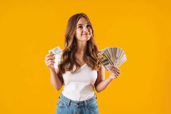 Foto einer entzückten Frau, die sich freut, während sie Dollargeld und Kreditkarte in der Hand hält — Stockfoto