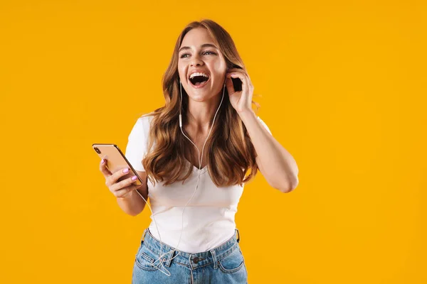 Εικόνα κοντινό στην χαρούμενη καυκάσια γυναίκα φορώντας βασικό μπλουζάκι χαμογελώντας ακούγοντας μουσική με κινητό και ακουστικά — Φωτογραφία Αρχείου