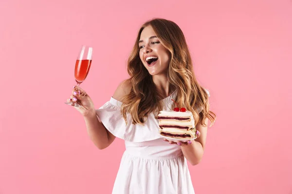 Bild av lycklig leende kvinna klädd i vit klänning titta på glas vin och innehav Piece of Cake — Stockfoto