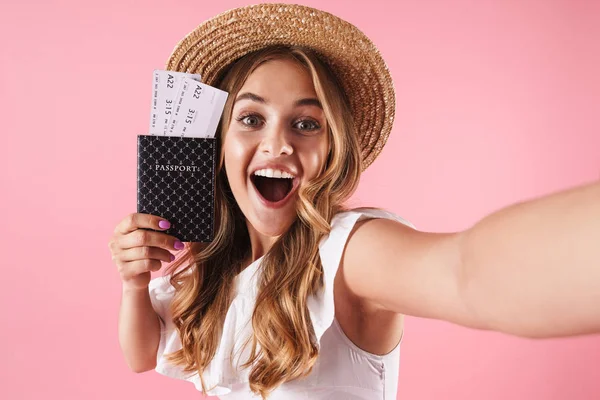 Junge hübsche Frau posiert isoliert über rosa Wand Hintergrund mit Pass mit Tickets machen ein Selfie mit der Kamera. — Stockfoto