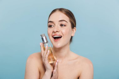 Pretty genç kadın yağ losyonu tutan mavi duvar arka plan üzerinde izole poz.