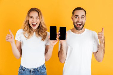 Cep telefonu tutarken birlikte başparmak gösteren mutlu çift erkek ve kadın Görüntü