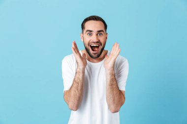 Heyecanlı genç çığlık mutlu sakallı adam mavi duvar arka plan üzerinde izole poz.