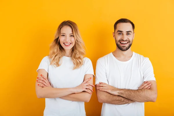 Πορτρέτο του όμορφο νεαρό ζευγάρι άντρας και γυναίκα σε βασικά μπλουζάκια χαμογελώντας και στέκεται με τα χέρια σταυρωτά — Φωτογραφία Αρχείου