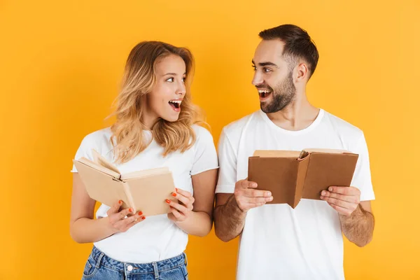 Image de couple heureux homme et femme exprimant leur intérêt tout en lisant des livres ensemble — Photo