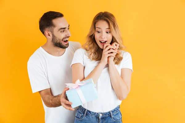 Imagen de pareja encantada regocijándose mientras hombre guapo dando caja de regalo a mujer hermosa — Foto de Stock