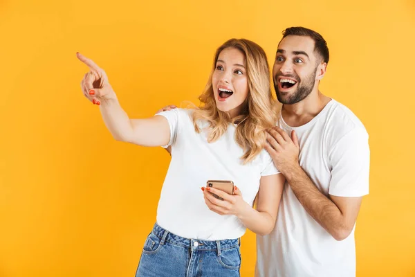 Animado alegre jovem casal de pé isolado — Fotografia de Stock