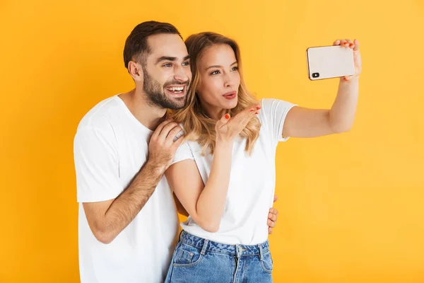 Opgewonden vrolijk jong stel staande geïsoleerd — Stockfoto