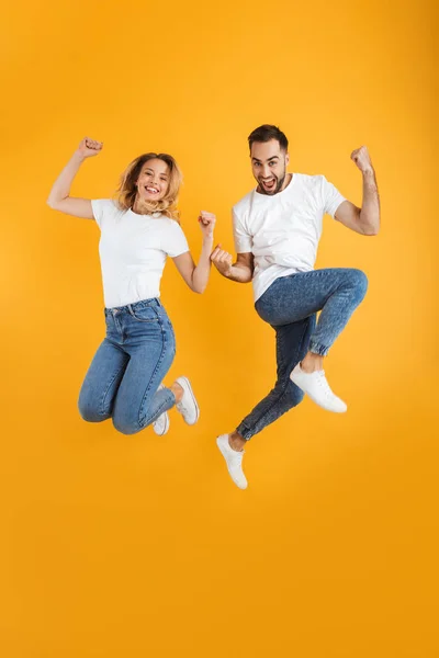 Imagen completa de pareja feliz regocijándose y saltando mientras se cierran los puños juntos — Foto de Stock