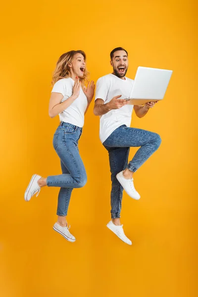 Imagen completa de pareja emocionada hombre y mujer regocijándose mientras mantiene unido el ordenador portátil — Foto de Stock