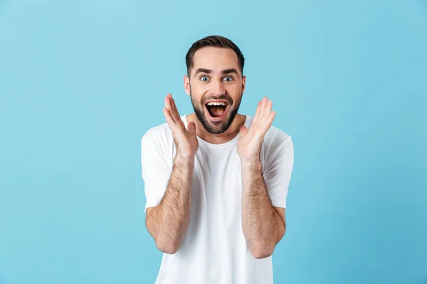 Aufgeregter junger schreiender glücklicher bärtiger Mann posiert isoliert über blauem Wandhintergrund. — Stockfoto