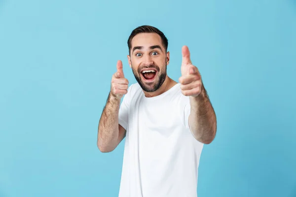 Fiatal sikoltozva boldog szakállas férfi pózol elszigetelt kék fal háttér mutatott Önnek. — Stock Fotó