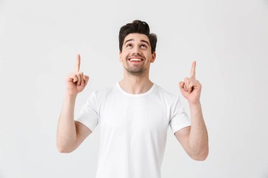 Heyecanlı genç adam beyaz duvar arka plan işaret üzerinde izole poz.