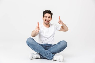Mutlu heyecanlı genç adam beyaz duvar arka plan üzerinde izole poz size işaret.