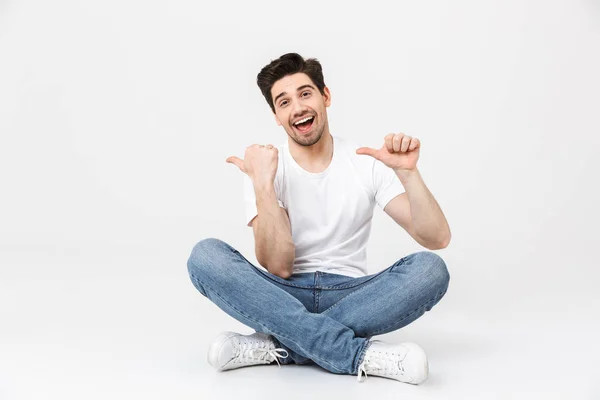 Excited young man posing isolated over white wall background pointing. — Stock Photo, Image