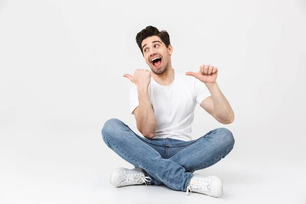 Excited young man posing isolated over white wall background pointing. — Stock Photo, Image