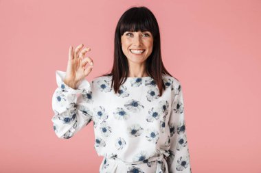 Güzel şaşırtıcı kadın tamam jest gösteren açık pembe arka plan duvar üzerinde izole poz.