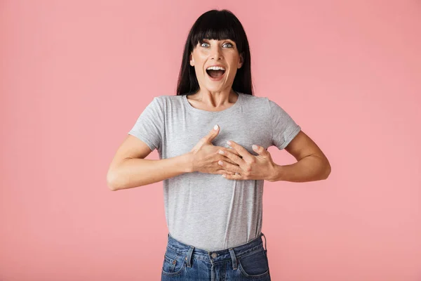 Mooie verbazingwekkende gelukkig opgewonden vrouw poseren geïsoleerd over licht roze achtergrond muur. — Stockfoto