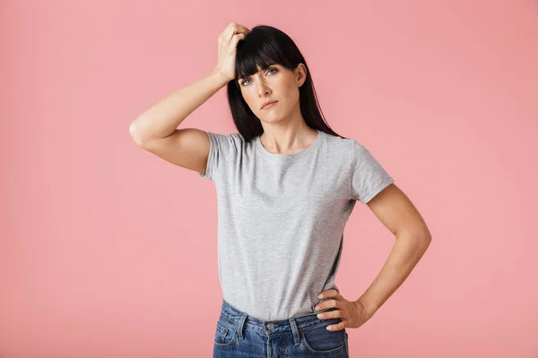 Mulher triste bonita descontente com dor de cabeça posando isolado sobre a parede de fundo rosa claro . — Fotografia de Stock