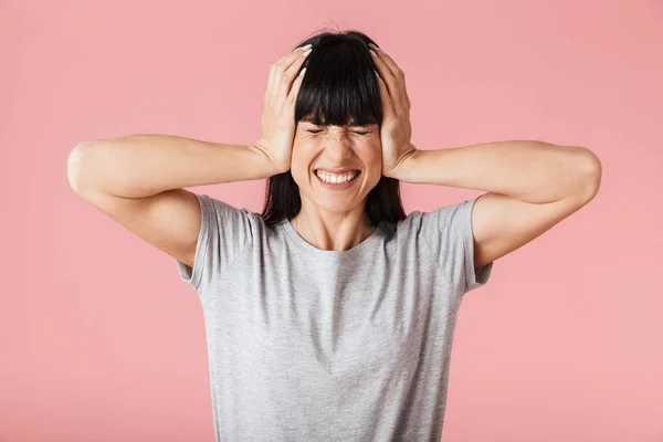 Mooie displease vrouw poseren geïsoleerd over licht roze achtergrond wandbekleding oren. — Stockfoto