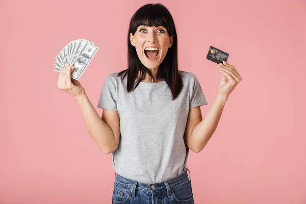 흥분 행복 한 여자 포즈 고립 위에 밝은 분홍색 배경 벽 보유 돈 과 신용 카드. — 스톡 사진