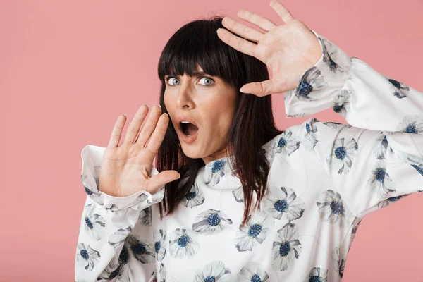 Verbazingwekkende bang geschokt vrouw poseren geïsoleerd over licht roze achtergrond muur. — Stockfoto