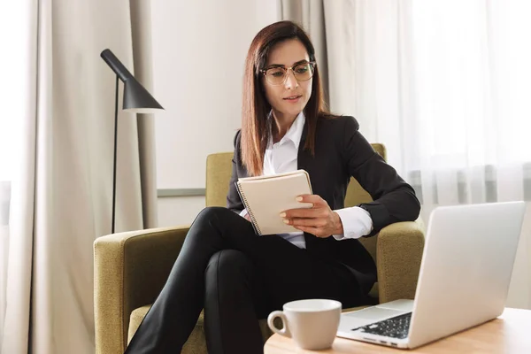 Young Business vrouw in formele slijtage kleding binnenshuis thuis werk met laptop computer schrijven notities. — Stockfoto