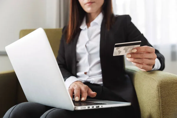 아름 다운 젊은 비즈니스 여자 에 공식적인 옷을 입고 실내 에서 가정 작업 노트북 컴퓨터 들고 신용 카드. — 스톡 사진