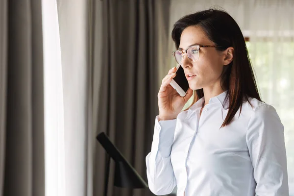 Increíble hermosa mujer de negocios joven en ropa de desgaste formal en el interior de casa hablando por teléfono móvil . —  Fotos de Stock