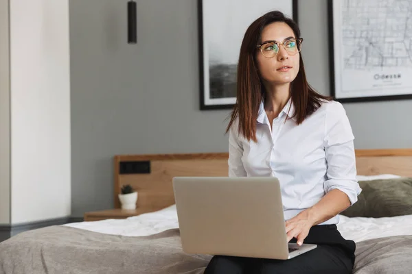 Retrato de mulher de negócios adulta pensativa digitando no laptop enquanto — Fotografia de Stock