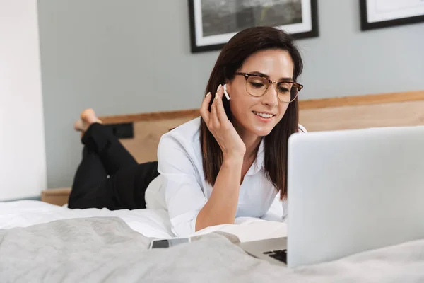 Arckép-ból elegáns felnőtt üzletasszony használ laptop és earpods — Stock Fotó