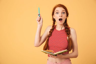 Şok genç güzel kızıl saçlı kadın sarı arka plan kitap okuma tutarak izole poz bir fikrim var.